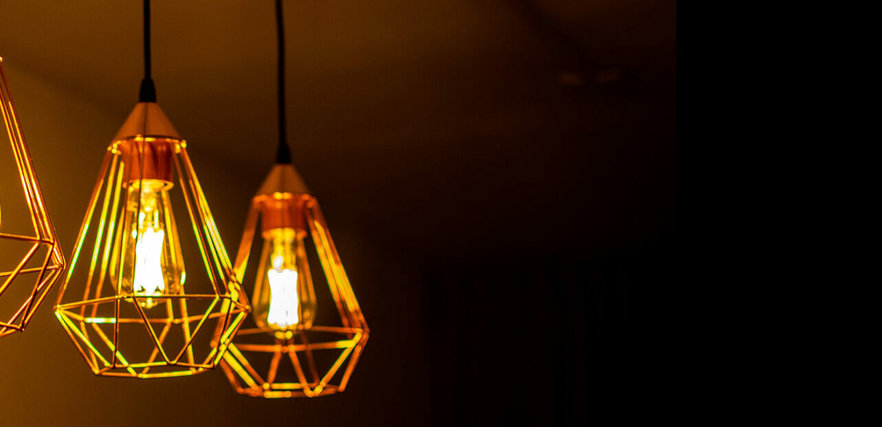 To hengende lamper med stor glødepære og gullskjerm
